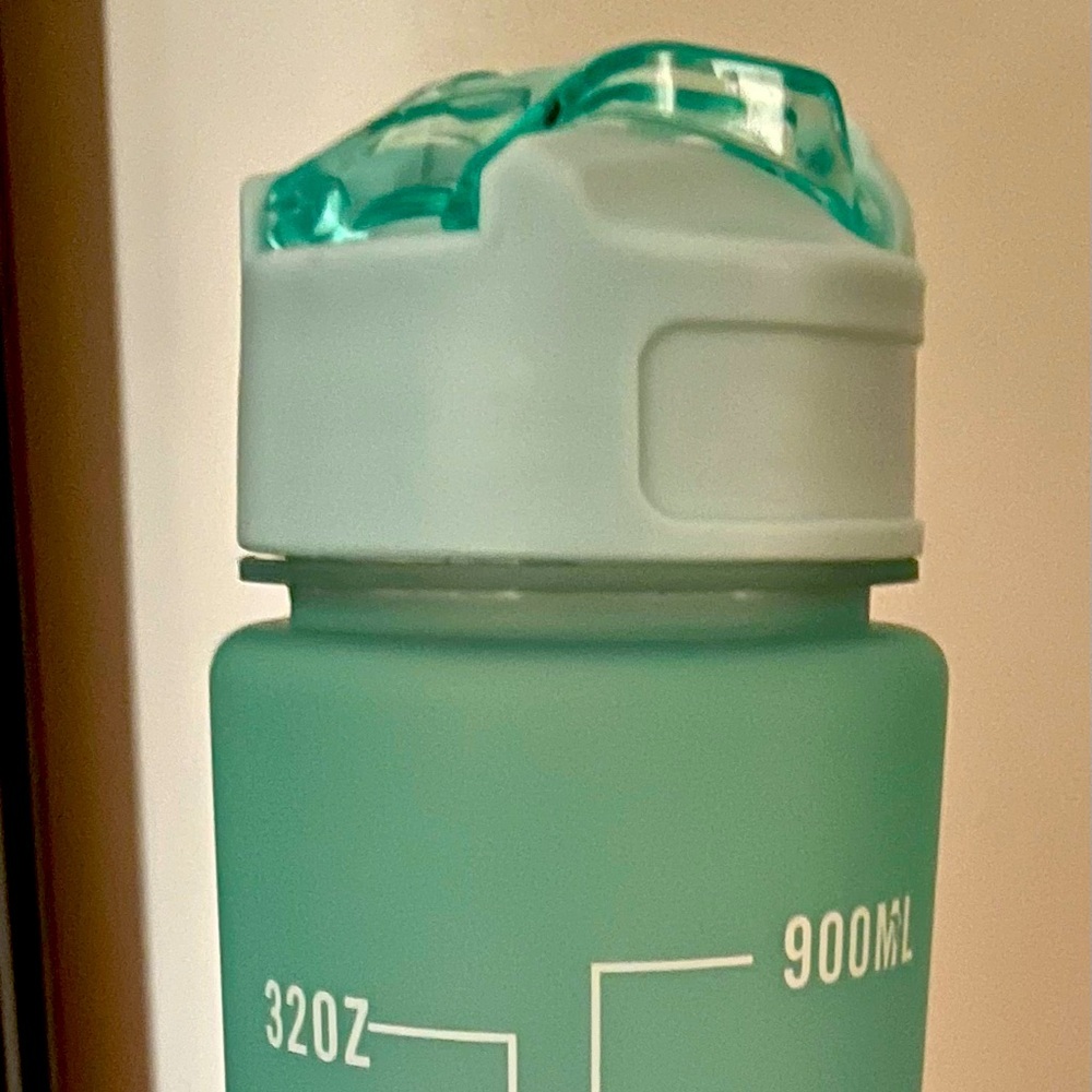 One liter water bottle with encouraging messages on the side. Latched top